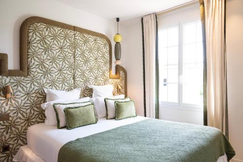 um quarto com uma cama grande e uma grande cabeceira. em Lou Cagnard em Saint-Tropez