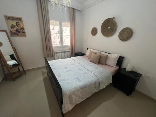 een slaapkamer met een bed en een raam bij Chott Meriem avec terrasse in Chott Meriem