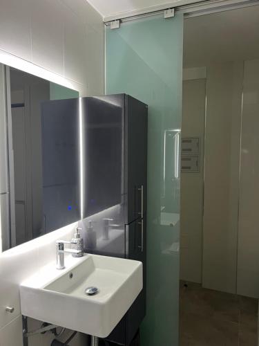 y baño con lavabo, espejo y ducha. en PUERTO BANUS Apartamento DUO en Marbella