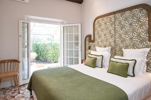 a bedroom with a large bed and a large window at Lou Cagnard in Saint-Tropez