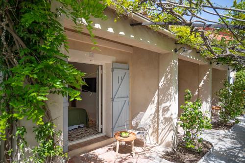 a porch of a house with a bed and a table at Lou Cagnard in Saint-Tropez