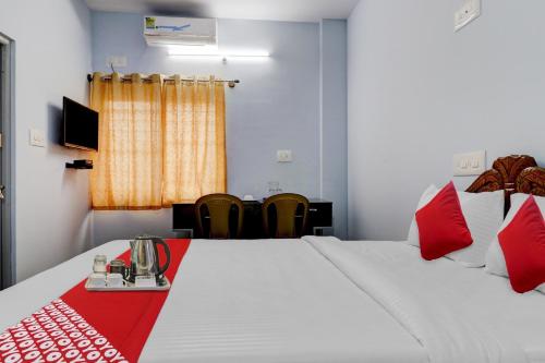 Habitación de hotel con cama con manta roja en Flagship Sai International Near Nagasandra Metro Station en Bangalore