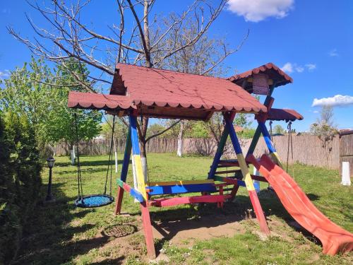 a playground with a swing and a roof at Eko Apartmani in Bački Petrovac