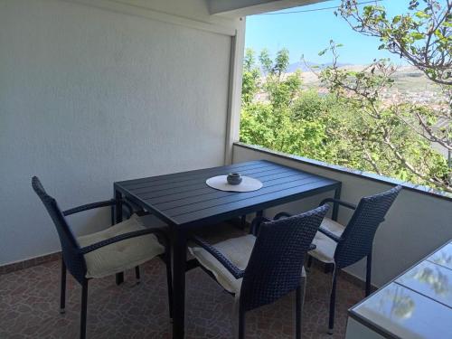 a table and chairs on a balcony with a window at Apartments Šešo in Pag