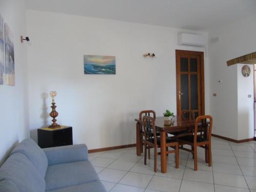 a living room with a blue couch and a table at Homiday - Residenza Il Moro in Roseto degli Abruzzi