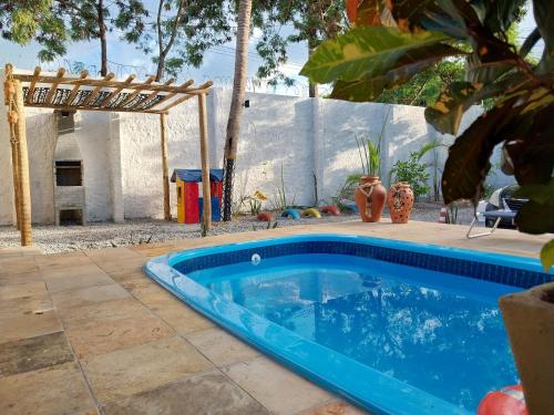 a blue swimming pool in a yard with a fence at CASA DA PIPA in Pipa
