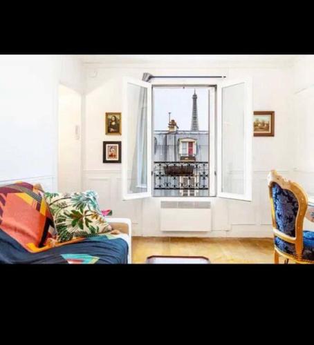 a living room with a couch and a window at Appart Paris vue Tour Eiffel in Paris