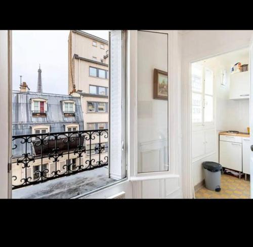 a room with a window with a view of a city at Appart Paris vue Tour Eiffel in Paris