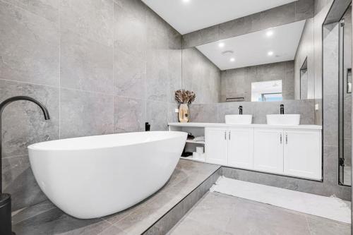 a bathroom with a large tub and two sinks at Private Paradise in Keysborough with pool in Keysborough