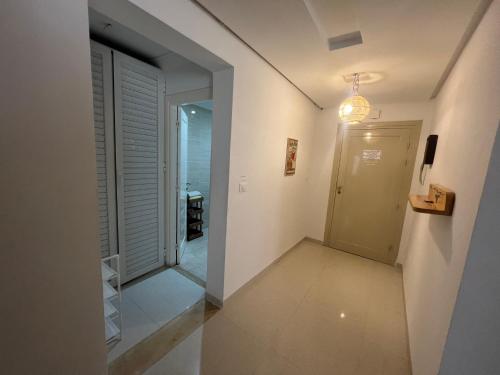 un pasillo con una puerta que conduce a una habitación en Chott Meriem avec terrasse en Chott Meriem