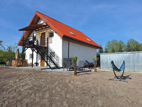 a small house with an orange roof and a playground at Węgorzewo- Apartamenty nad stawem in Węgorzewo