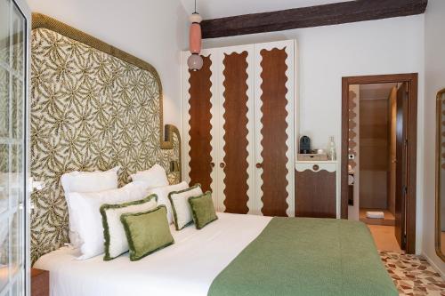 a bedroom with a large white bed with pillows at Lou Cagnard in Saint-Tropez