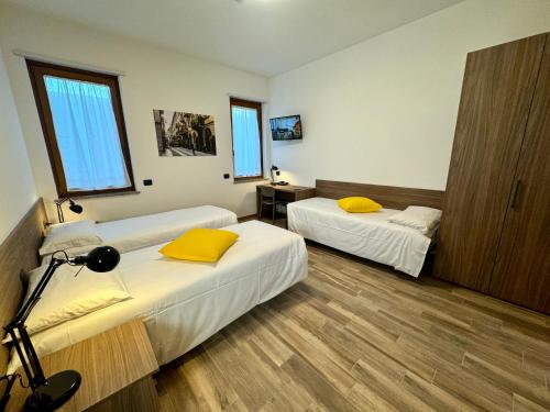 zwei Betten in einem Zimmer mit zwei Fenstern in der Unterkunft Corte Milano in Rozzano