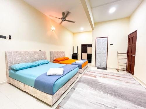 - une chambre avec 2 lits et un ventilateur de plafond dans l'établissement Homestay Desa (Bukit Baru, Melaka), à Malacca