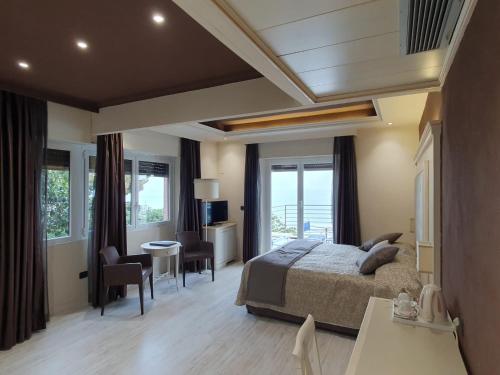 a bedroom with a bed and a table and chairs at Hotel Regina in Alassio