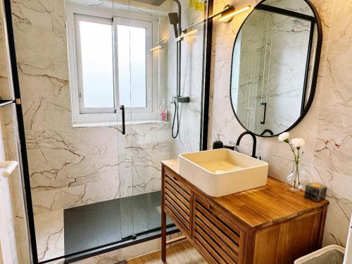 een badkamer met een wastafel en een spiegel bij Paradis de Vanves in Vanves