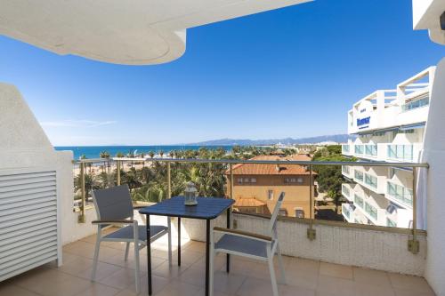 balcón con mesa, sillas y vistas al océano en Acacias Apartamentos Salou en Salou