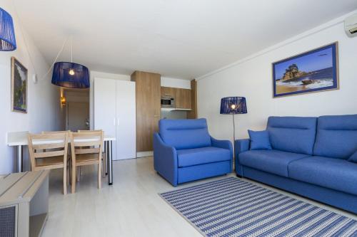 サロウにあるAcacias Apartamentos Salouのリビングルーム(青い椅子2脚、テーブル付)