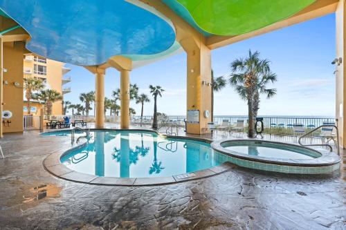 una piscina en un complejo con el océano en el fondo en Splash Beach Resort by Panhandle Getaways, en Panama City Beach