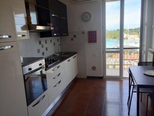 a kitchen with a table and a view of the ocean at Casa ANNA, casa tua in Le Grazie