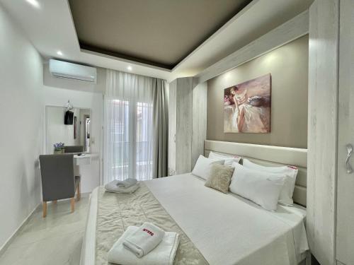 1 dormitorio con 1 cama blanca grande y baño en Myrto Rooms, en Pefkohori