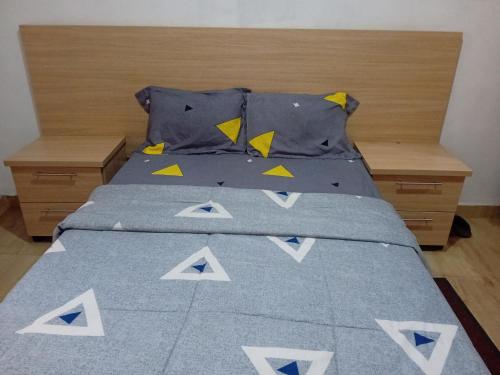 uma cama com um edredão e almofadas azuis em Casa Linda em Maputo