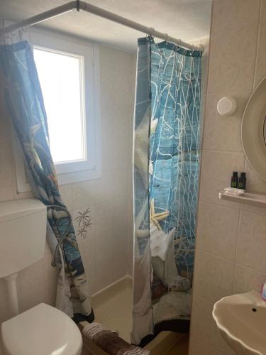 a bathroom with a shower with a blue shower curtain at Pansion Katerina in Skala Eresou