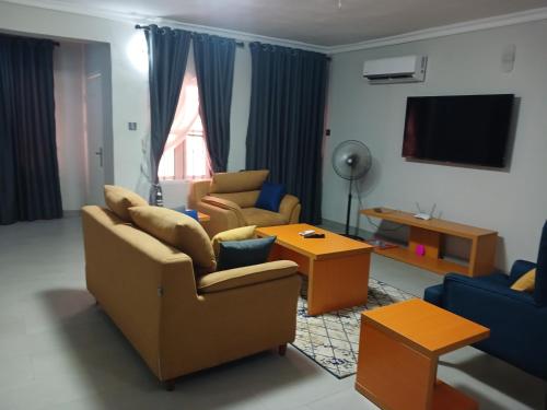 - un salon avec deux canapés et une télévision dans l'établissement D little luxuries Apartment, à Ibadan