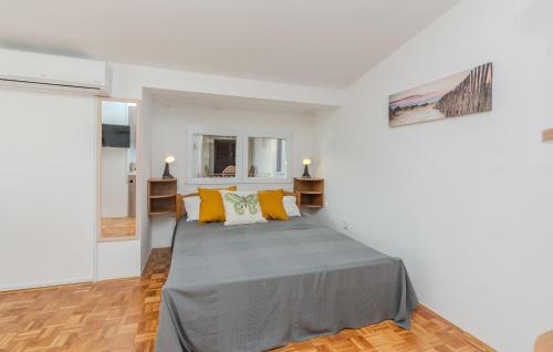 1 dormitorio blanco con 1 cama grande con almohadas amarillas en Gorgeous Apartment In Nin With Kitchen en Nin