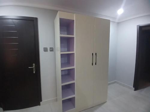 - un placard blanc avec une porte et des étagères noires dans l'établissement D little luxuries Apartment, à Ibadan