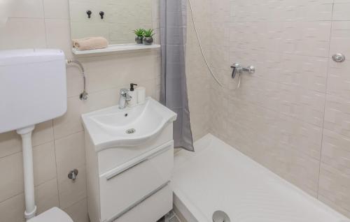 y baño blanco con lavabo y ducha. en Gorgeous Apartment In Nin With Kitchen en Nin