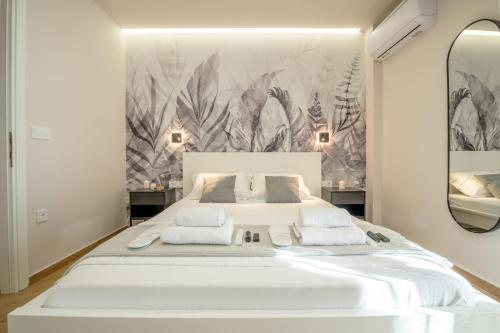 a bedroom with a large white bed with a large mirror at Dreamin Athens - Monastiraki Apartments in Athens