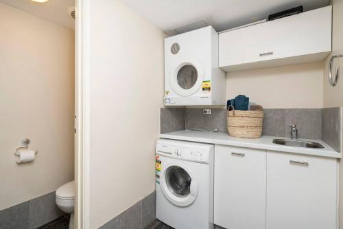 a small laundry room with a washer and dryer at Sandcastles At The Beach Outstanding Location! in Perth