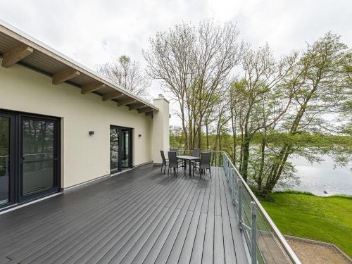 una terrazza in legno con tavolo e sedie. di Tao-Suite mit Dachterrasse, Sauna und Kamin a Krakow am See