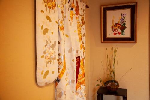 una cortina colgando en una pared junto a una foto en Samurai Suite 2 , 15mins from Kyoto Eki , 5 mins to Arashiyama, en Kioto