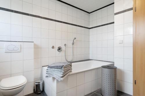 a white bathroom with a tub and a toilet at Ferienwohnung in Spelle in Spelle