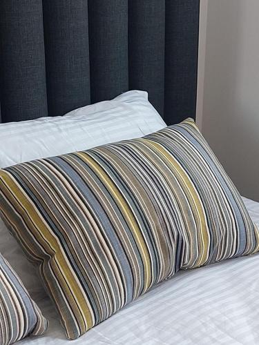 a bed with a striped pillow on top of it at Apartman M306 Zlatibor in Palisat