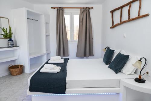 un letto bianco in una stanza con finestra di Navis studio a Zefiría
