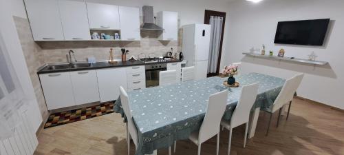 a kitchen with a table and chairs and a kitchen with white cabinets at Casa Terra Del Sole in Pula