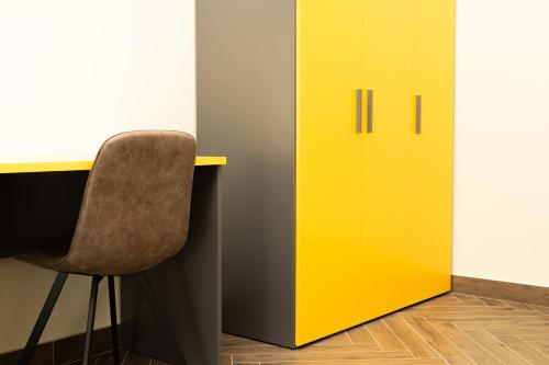 żółtą szafkę obok biurka z krzesłem w obiekcie ABeB w mieście Colleferro