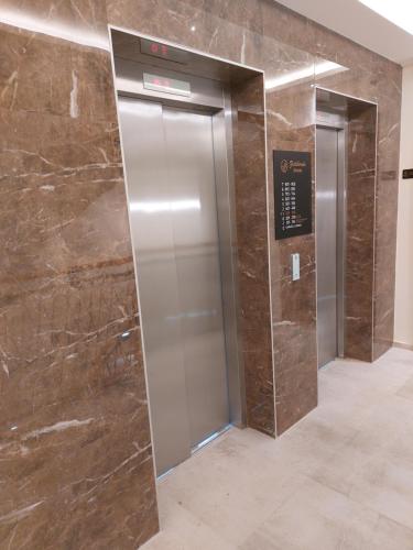 an elevator lobby with two elevators in a building at Apartman M306 Zlatibor in Palisad