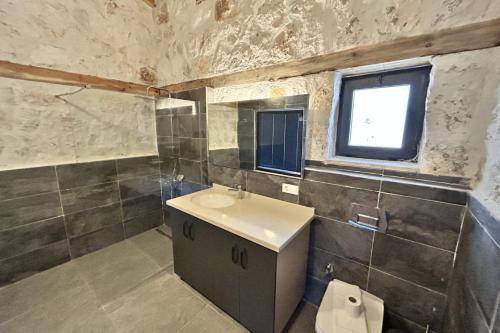 La salle de bains est pourvue d'un lavabo, de toilettes et d'une fenêtre. dans l'établissement Villa Smiles, à Patara