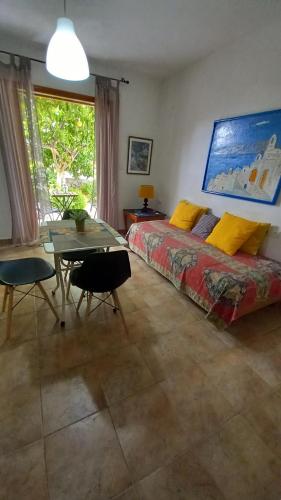 a bedroom with a bed and a table and a dining room at poros apartment in garden in Poros