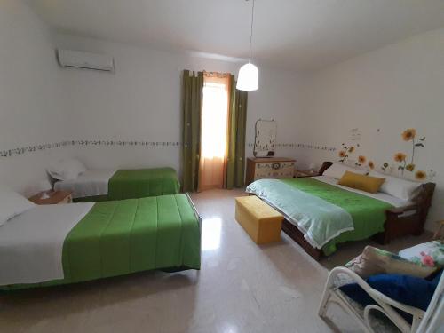 um quarto com 2 camas e uma sala de estar com um sofá em Casa Vacanze Ciccinè em Capaci