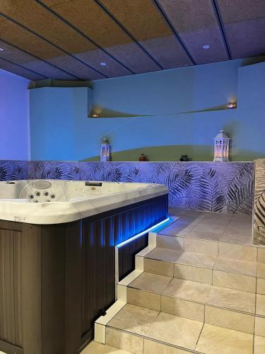 a lobby with a bar with blue lighting and stairs at Hotel Regina in Alassio