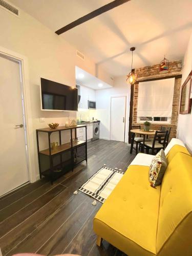 a living room with a yellow couch and a kitchen at Gilber apartment sleep 3 in London
