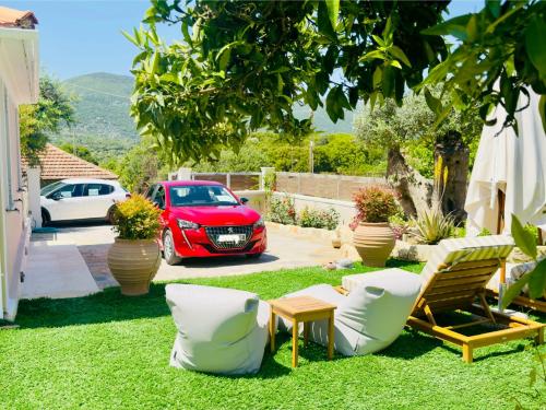 a garden with a red car parked in a driveway at Marigoulis Home in Sami
