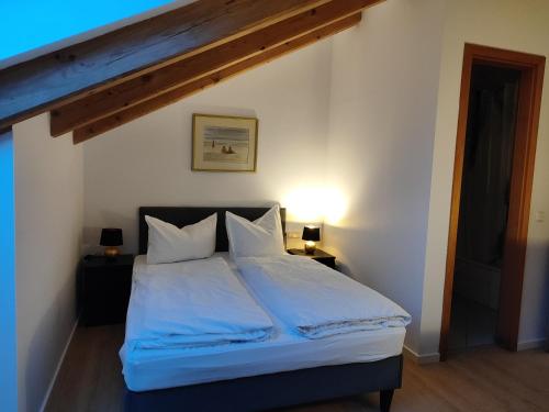- une chambre avec un lit doté de draps et d'oreillers blancs dans l'établissement Estelada Boarding Houses Zorneding, à Zorneding