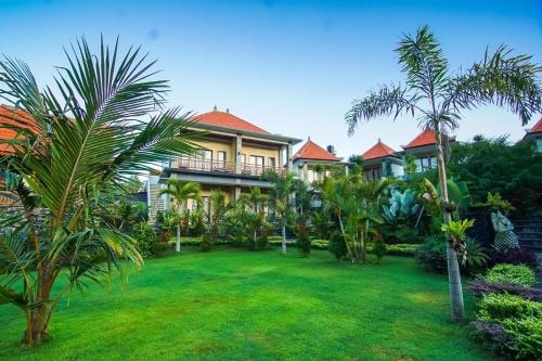 a large house with a yard with palm trees at Villa Danu in Kintamani