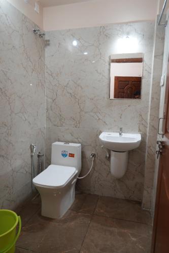 a bathroom with a toilet and a sink at HILL PALACE RESIDENCY COORG in Virajpet